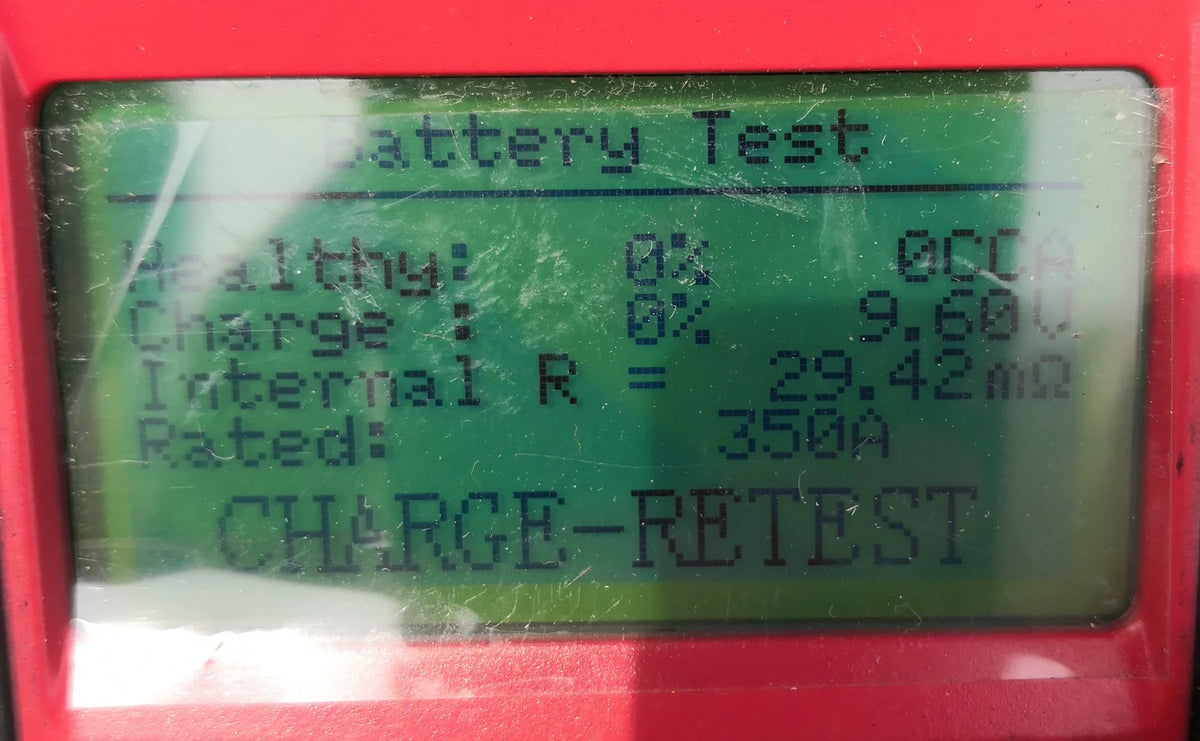 Electronic battery tester displaying a Charge-Retest message