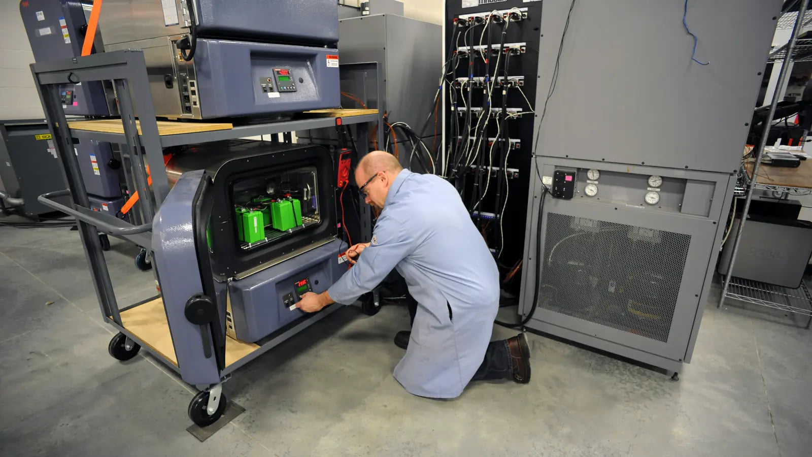 Technician working with professional battery testing equipment in a laboratory