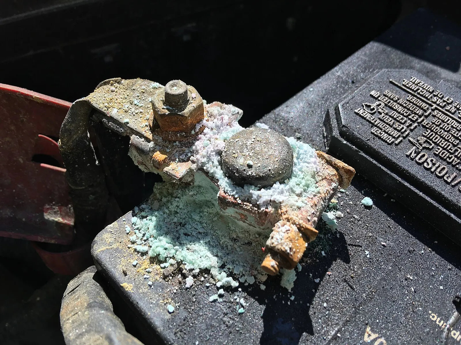 Heavy corrosion around a car battery terminal before cleaning